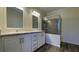 Bathroom featuring dual sinks, white cabinets and a large tile shower with glass door at 3722 Binnacle Dr, Tampa, FL 33611