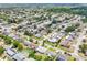 High-angle view displaying a neighborhood's layout, houses, streets, and dense vegetation in a clear, sunny setting at 3813 Luma Dr, Holiday, FL 34691