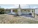 Back exterior view of the home featuring a concrete patio and yard with a mix of grass and bare spots at 3813 Luma Dr, Holiday, FL 34691
