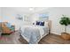 Comfortable bedroom with a large bed, wood floors, and a sitting chair at 3813 Luma Dr, Holiday, FL 34691