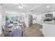 Dining and kitchen with hardwood floors and white cabinets, open to the bright living room at 3813 Luma Dr, Holiday, FL 34691