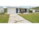 Inviting single-story home with a well-manicured lawn, private driveway, and attached garage at 3813 Luma Dr, Holiday, FL 34691