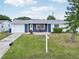 Front exterior view of a blue and white home with a well-maintained lawn and small table set at 3813 Luma Dr, Holiday, FL 34691
