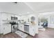 Bright kitchen featuring stainless steel appliances, white cabinetry, granite countertops, and wood flooring at 3813 Luma Dr, Holiday, FL 34691