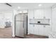 Bright kitchen featuring stainless steel appliances, white cabinetry, granite countertops, and wood flooring at 3813 Luma Dr, Holiday, FL 34691