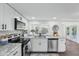 Bright kitchen featuring stainless steel appliances, white cabinetry, granite countertops, and wood flooring at 3813 Luma Dr, Holiday, FL 34691