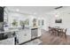 Bright kitchen featuring stainless steel appliances, white cabinetry, granite countertops, and wood flooring at 3813 Luma Dr, Holiday, FL 34691