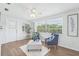 Cozy living room with wood floors, a ceiling fan, and large windows bringing in natural light at 3813 Luma Dr, Holiday, FL 34691
