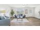 Bright living room with hardwood floors, blue sofa, and a chair, complemented by art on the walls at 3813 Luma Dr, Holiday, FL 34691