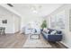Bright living room featuring hardwood floors, natural light, and a stylish navy blue sofa at 3813 Luma Dr, Holiday, FL 34691