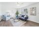 Living room with hardwood floors, a navy blue sofa, and a chair, with natural light from a window at 3813 Luma Dr, Holiday, FL 34691