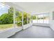 Enclosed sunroom features refreshing tropical landscaping views, light walls, and gray floors at 3813 Luma Dr, Holiday, FL 34691