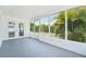 Bright sunroom with large windows offering views of lush tropical landscaping, and a double door at 3813 Luma Dr, Holiday, FL 34691