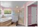 Bright bathroom featuring a glass-enclosed shower, soaking tub, and tiled floor at 4022 Valrico Grove Dr, Valrico, FL 33594