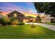 Well-maintained home featuring lush green lawn, mature trees, and a charming driveway leading to a welcoming entrance at 4022 Valrico Grove Dr, Valrico, FL 33594