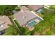 Aerial view showcasing a private screened-in pool and a well-maintained backyard with lush green grass at 4022 Valrico Grove Dr, Valrico, FL 33594
