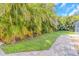 Lush backyard space with a tiled patio, green grass, and mature landscaping providing privacy at 4915 Pennsbury Dr, Tampa, FL 33624