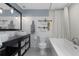 Bright bathroom features a modern vanity with dual vessel sinks, subway tile walls, and a soaking tub at 4915 Pennsbury Dr, Tampa, FL 33624