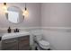 Well-lit half bath with modern vanity, decorative mirror, and contemporary fixtures at 4915 Pennsbury Dr, Tampa, FL 33624