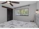 Bright bedroom with a ceiling fan, louvered closet doors, and window overlooking lush greenery at 4915 Pennsbury Dr, Tampa, FL 33624