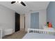 Bright bedroom with blue accent wall, white bed, louvered closet doors, and a gray ceiling fan at 4915 Pennsbury Dr, Tampa, FL 33624