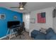 Bright room with blue accent wall, equipped with a desk, chair, couch, and ceiling fan, ideal for an office space at 4915 Pennsbury Dr, Tampa, FL 33624