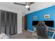 Bedroom featuring blue accent wall, ceiling fan, dark closet doors, and desk with two large monitors at 4915 Pennsbury Dr, Tampa, FL 33624