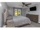 Comfortable bedroom with a queen bed, ceiling fan, gray walls, a large window, and wooden dressers at 4915 Pennsbury Dr, Tampa, FL 33624