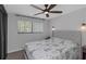 Comfortable bedroom with a ceiling fan, large window, and a stylish Eiffel Tower themed bedspread at 4915 Pennsbury Dr, Tampa, FL 33624