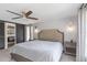 Stylish bedroom featuring a king bed, a ceiling fan, decor sconces, with a doorway leading into the bathroom at 4915 Pennsbury Dr, Tampa, FL 33624