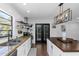 Modern kitchen features granite counters, stainless appliances, and sleek white cabinets and black french doors at 4915 Pennsbury Dr, Tampa, FL 33624