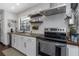 Modern kitchen showcasing stainless steel appliances, white cabinets, and open shelving at 4915 Pennsbury Dr, Tampa, FL 33624