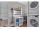 Convenient laundry room featuring stacked washer and dryer, storage, and a wash sink at 4915 Pennsbury Dr, Tampa, FL 33624