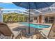 A private screened-in pool with lounge chairs, an umbrella, an outdoor shower, and lush landscaping at 4915 Pennsbury Dr, Tampa, FL 33624
