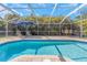 Enjoy the sparkling screened-in pool with a lounge and dining area, surrounded by tropical foliage at 4915 Pennsbury Dr, Tampa, FL 33624