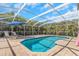 A private screened-in pool with lounge chairs, an umbrella, and lush landscaping at 4915 Pennsbury Dr, Tampa, FL 33624