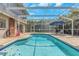 Refreshing backyard pool area featuring a screened-in patio with ample seating and clear blue water at 4915 Pennsbury Dr, Tampa, FL 33624