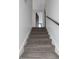 Carpeted stairs ascend to the upper level, with a wooden handrail providing support and a doorway offering a glimpse of the bedroom at 4915 Pennsbury Dr, Tampa, FL 33624