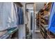 Organized walk-in closet with shelving and hanging space, featuring a mirror and views into the connected bathroom at 4915 Pennsbury Dr, Tampa, FL 33624