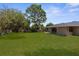 Large backyard featuring a lush green lawn and a wooden privacy fence at 5193 Higate Rd, Spring Hill, FL 34609