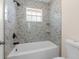 Updated bathroom featuring modern tile and fixtures, plus a shower-tub combo with marble-like tile at 5193 Higate Rd, Spring Hill, FL 34609