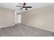A bedroom with neutral walls, carpeted floors, ceiling fan, and a closet visible from the entry door at 5193 Higate Rd, Spring Hill, FL 34609