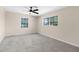 A bedroom with neutral walls, two large windows, a ceiling fan, and carpeted floors at 5193 Higate Rd, Spring Hill, FL 34609