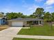Attractive home with a well-kept lawn, mature trees, and a two-car garage at 5193 Higate Rd, Spring Hill, FL 34609