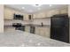 Kitchen with stone countertops, beige cabinets, and stainless steel appliances at 5193 Higate Rd, Spring Hill, FL 34609