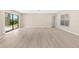 Spacious living room with light wood flooring, large windows, and ample natural light at 5193 Higate Rd, Spring Hill, FL 34609