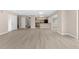 Open-concept living area showcasing light wood floors, neutral walls, and seamless flow to the kitchen at 5193 Higate Rd, Spring Hill, FL 34609