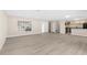 Inviting open-concept living space with light wood flooring connecting to a modern kitchen at 5193 Higate Rd, Spring Hill, FL 34609