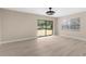 Bright living room with large windows and sliding glass door, light wood floors, and neutral walls at 5193 Higate Rd, Spring Hill, FL 34609