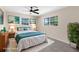 The staged main bedroom features calming artwork, a lush green houseplant, and modern bedroom furniture at 5193 Higate Rd, Spring Hill, FL 34609